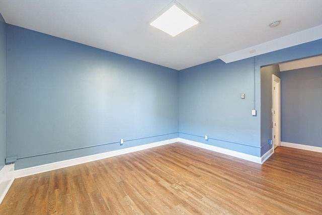 spare room featuring wood finished floors and baseboards