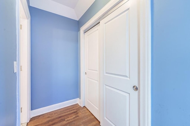 hallway featuring dark wood finished floors and baseboards