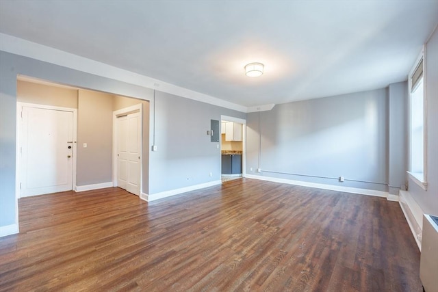 empty room featuring dark wood-style flooring and baseboards