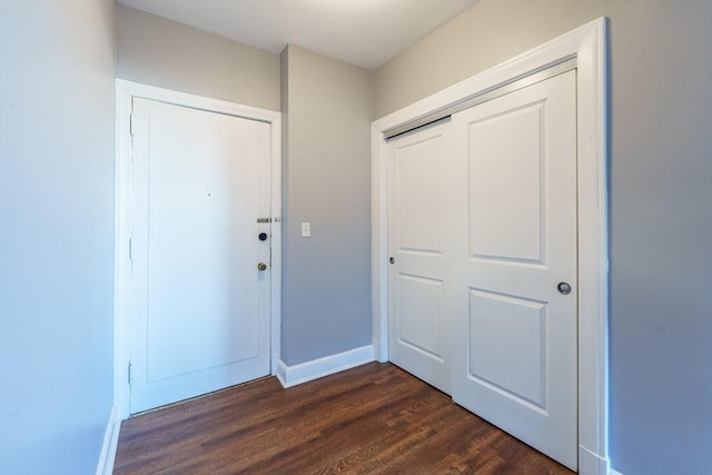 foyer entrance with dark wood finished floors and baseboards