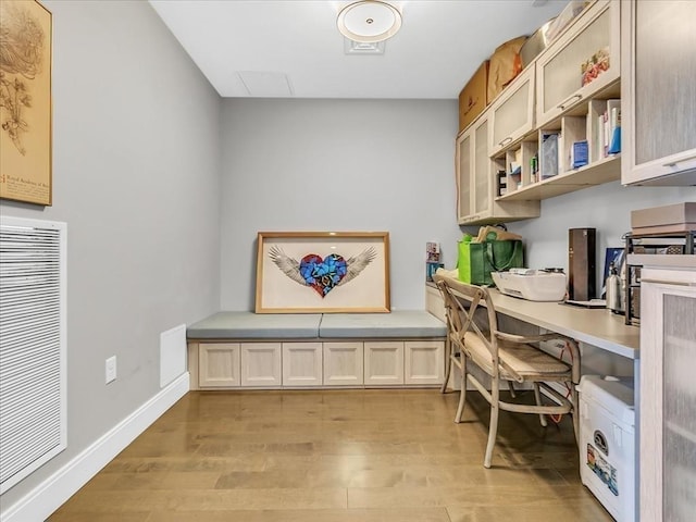 home office with light wood-type flooring and baseboards
