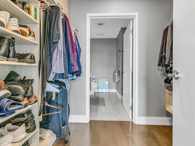 walk in closet with visible vents and wood finished floors