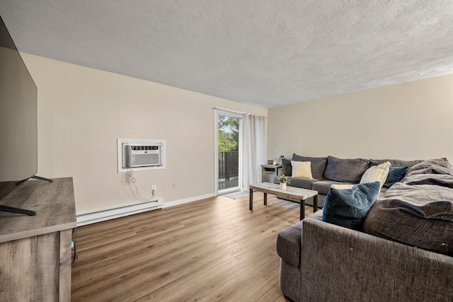 120 Eldridge St Unit 5, Taunton, MA 02780 - living area with baseboard heating, wood finished floors, a textured ceiling, a wall mounted air conditioner, and baseboards