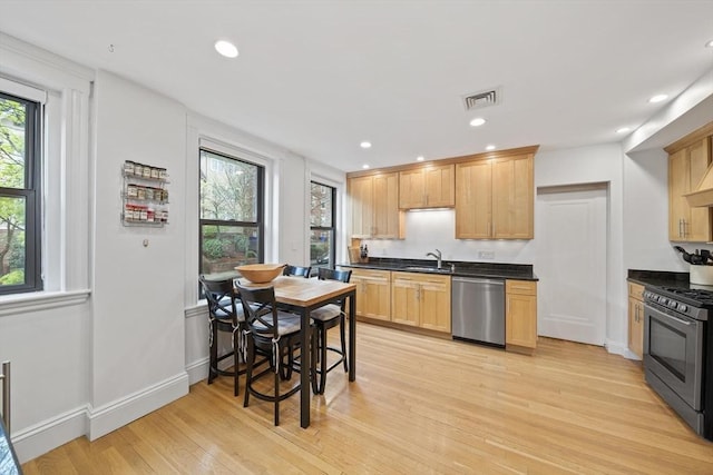4 Fairbanks Unit 2, Brookline, MA 02446 - kitchen featuring stainless steel appliances, dark countertops, a sink, and light wood-style flooring