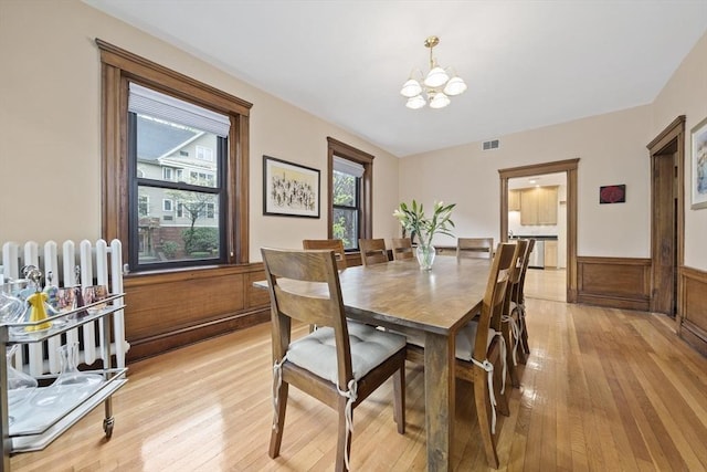 4 Fairbanks Unit 2, Brookline, MA 02446 - dining room with an inviting chandelier, wainscoting, radiator heating unit, light wood-type flooring, and visible vents