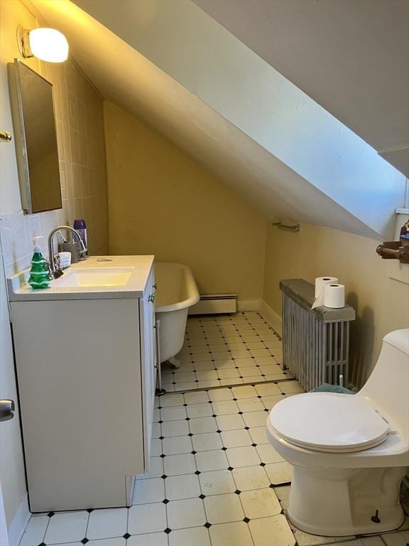 bathroom with lofted ceiling, toilet, a baseboard heating unit, vanity, and tile patterned floors