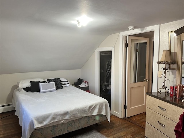 bedroom with vaulted ceiling, dark wood-style flooring, and baseboard heating