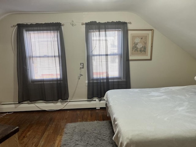 bedroom with a baseboard radiator, vaulted ceiling, and wood finished floors