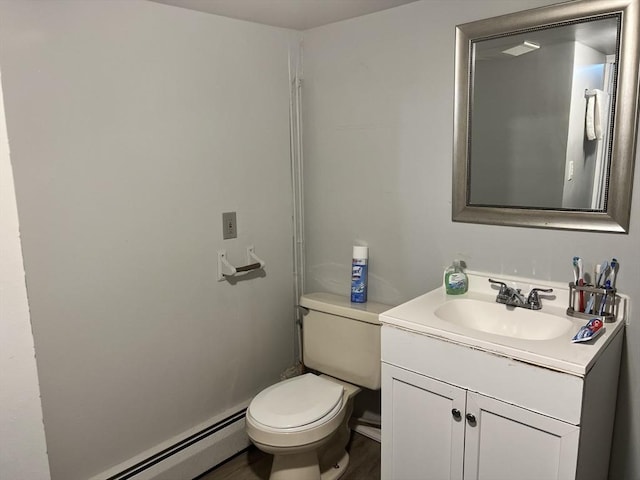 half bathroom featuring toilet, baseboard heating, and vanity