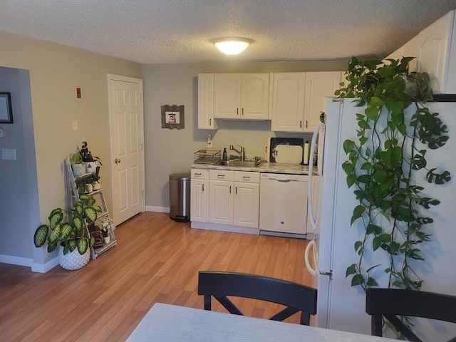 10 Nova Unit B, Pepperell, MA 01463 - kitchen featuring dishwasher, a sink, white cabinetry, light wood-style floors, and light countertops