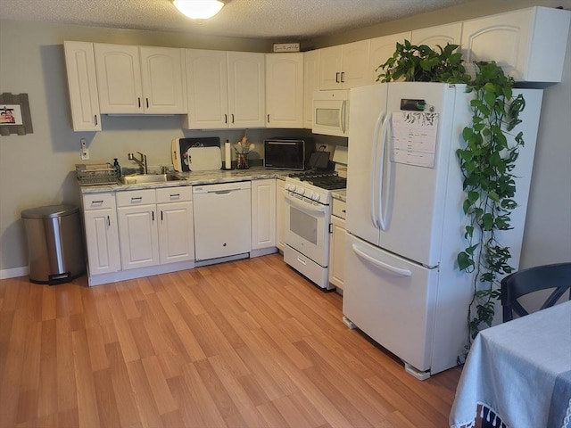 10 Nova Unit B, Pepperell, MA 01463 - kitchen with white appliances, white cabinetry, a sink, light wood-type flooring, and a textured ceiling