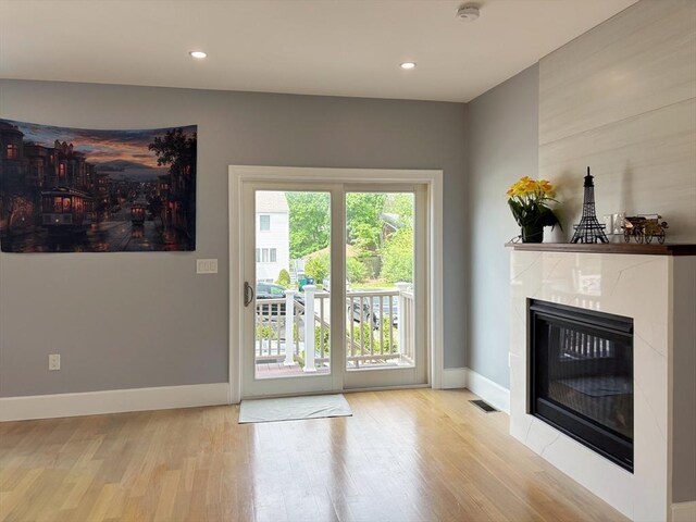 entryway featuring wood finished floors, a fireplace, baseboards, and recessed lighting