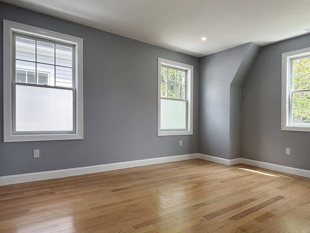 additional living space with light wood-style flooring, baseboards, and recessed lighting
