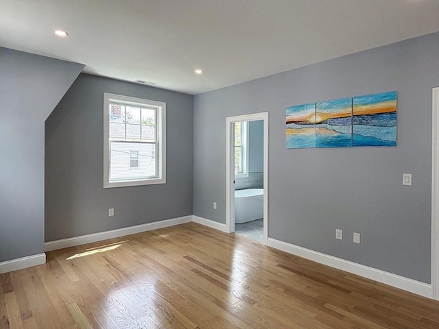 unfurnished bedroom with wood finished floors, baseboards, and recessed lighting