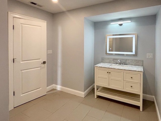 bathroom with baseboards, vanity, and tile patterned floors