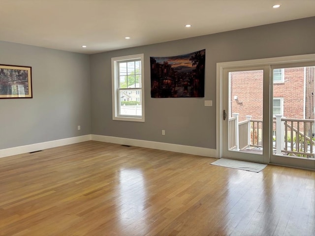 spare room featuring light wood-style flooring, baseboards, and recessed lighting