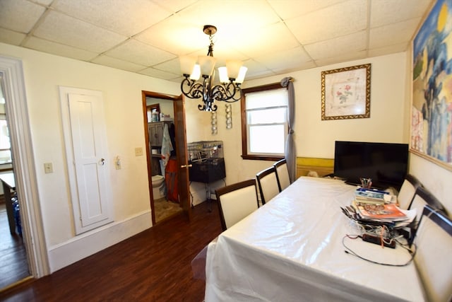 dining room featuring an inviting chandelier, a drop ceiling, and dark hardwood / wood-style flooring