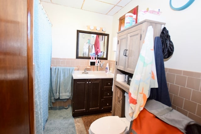 bathroom with tile walls, vanity, and toilet