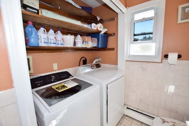 washroom with a baseboard radiator, washer and dryer, and light tile patterned floors