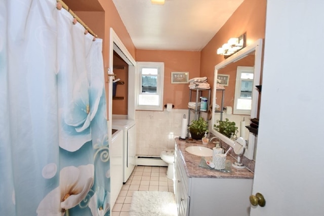 bathroom featuring vanity, toilet, baseboard heating, independent washer and dryer, and tile patterned flooring