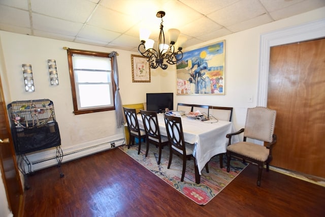 dining space featuring a drop ceiling, a baseboard heating unit, a notable chandelier, and dark hardwood / wood-style floors