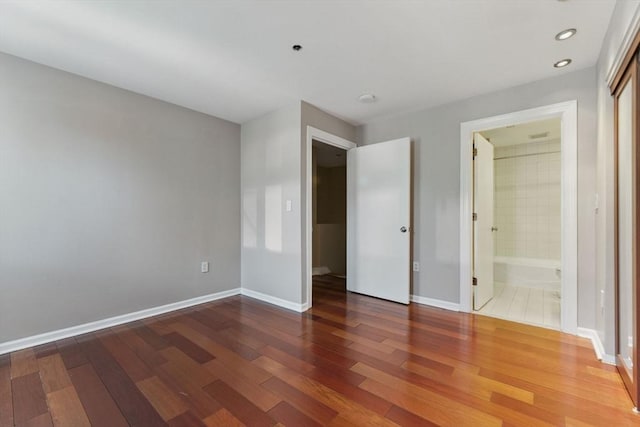 10 Rogers St Unit Ph19, Cambridge, MA 02142 - unfurnished bedroom featuring baseboards, connected bathroom, recessed lighting, and wood finished floors