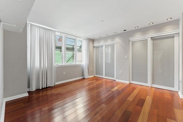 10 Rogers St Unit Ph19, Cambridge, MA 02142 - unfurnished bedroom featuring wood-type flooring, baseboards, multiple closets, and recessed lighting