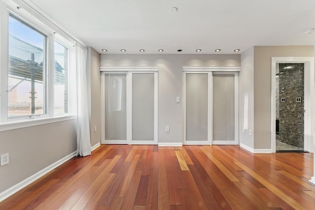 10 Rogers St Unit Ph19, Cambridge, MA 02142 - unfurnished bedroom with wood-type flooring, baseboards, and multiple closets