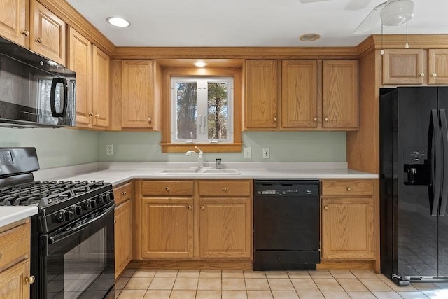 kitchen with light tile patterned floors, recessed lighting, a sink, black appliances, and light countertops