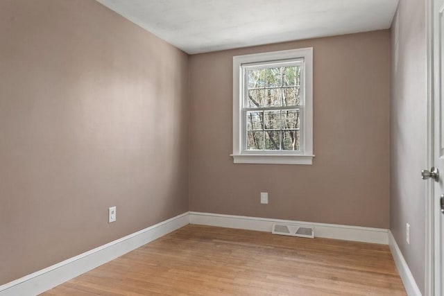 spare room with baseboards, visible vents, and light wood-type flooring