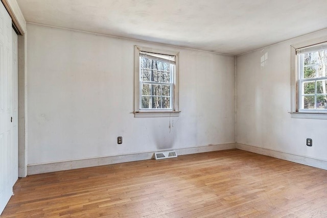 unfurnished room featuring visible vents, baseboards, and light wood finished floors