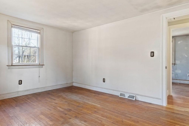 empty room with light wood finished floors and visible vents