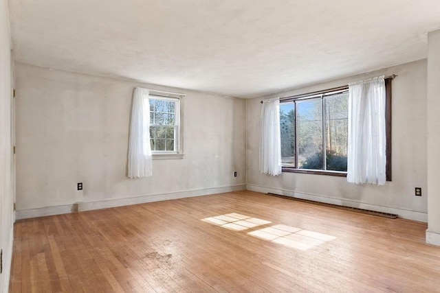 unfurnished room with baseboards, baseboard heating, and hardwood / wood-style floors