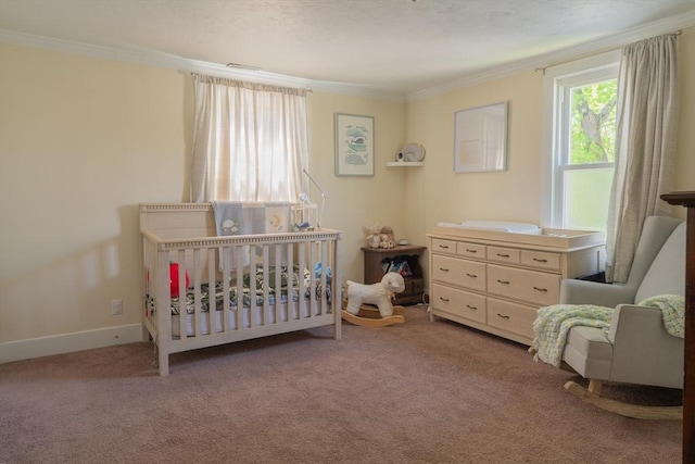 carpeted bedroom featuring crown molding, a crib, and baseboards
