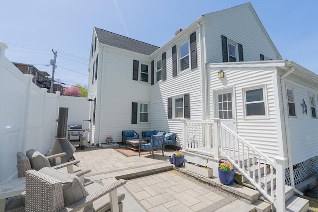 rear view of property featuring a fenced backyard, a patio area, and an outdoor hangout area