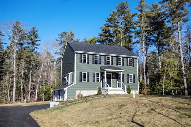 colonial inspired home with a garage and a front yard