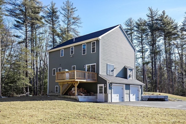 rear view of house with a yard, a garage, and a deck