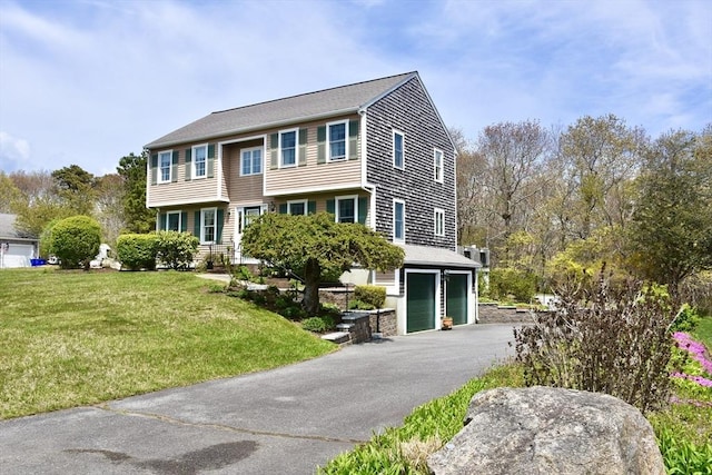 view of front of property with an attached garage, driveway, and a front lawn