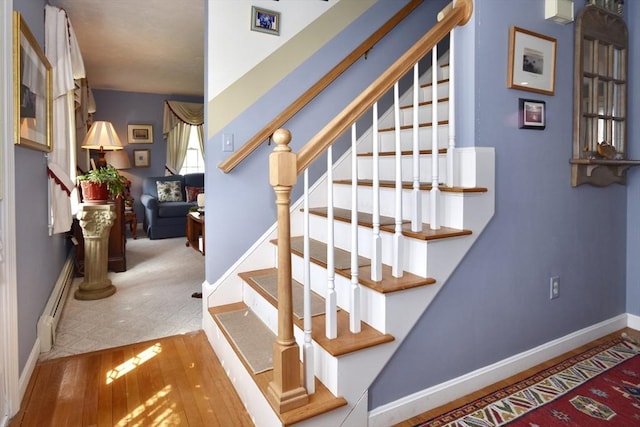 staircase featuring baseboards and wood finished floors
