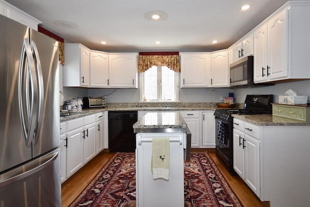 kitchen featuring black appliances, dark wood finished floors, a sink, white cabinetry, and recessed lighting