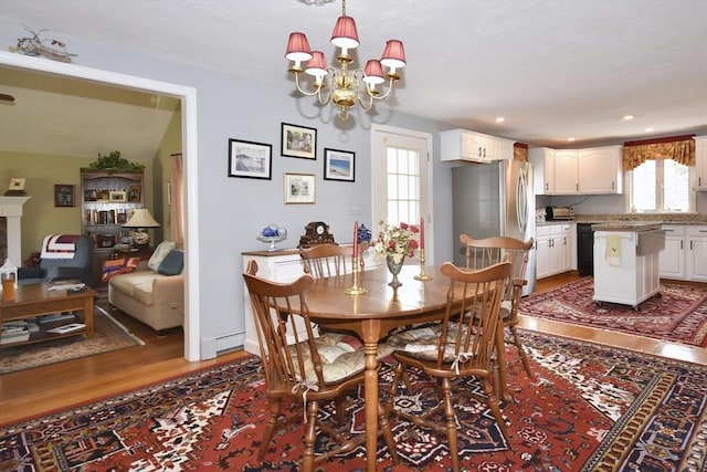 dining space featuring wood finished floors, a chandelier, healthy amount of natural light, and recessed lighting