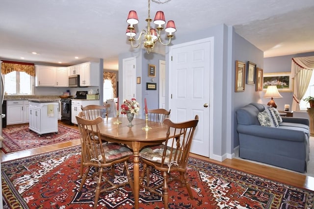 dining room with wood finished floors, a chandelier, and recessed lighting