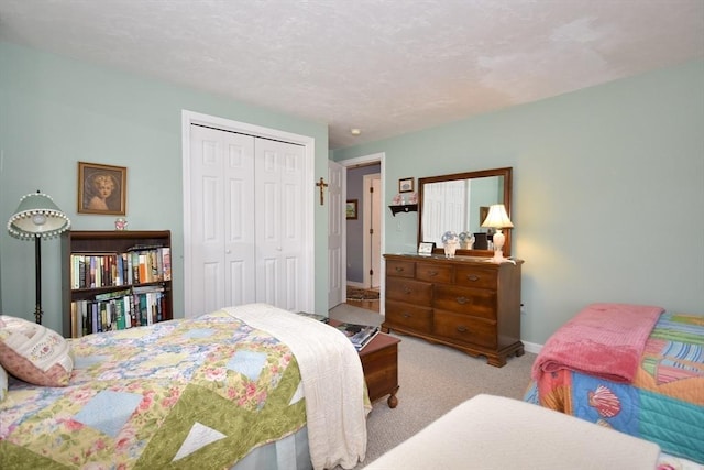 carpeted bedroom featuring a closet and baseboards