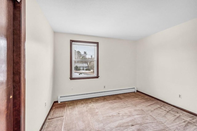 carpeted empty room featuring baseboard heating and baseboards