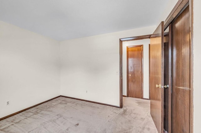 unfurnished room featuring baseboards and carpet