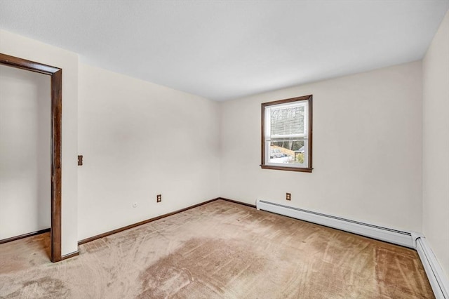 spare room featuring baseboard heating, baseboards, and carpet