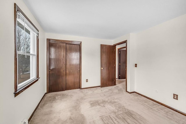 unfurnished bedroom with light colored carpet, baseboards, and a closet