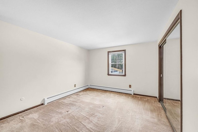 unfurnished bedroom with baseboards, a baseboard heating unit, and carpet