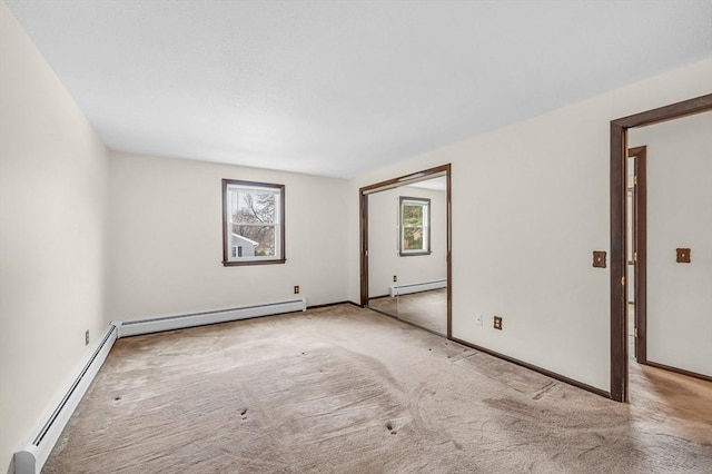 carpeted spare room featuring baseboards and baseboard heating