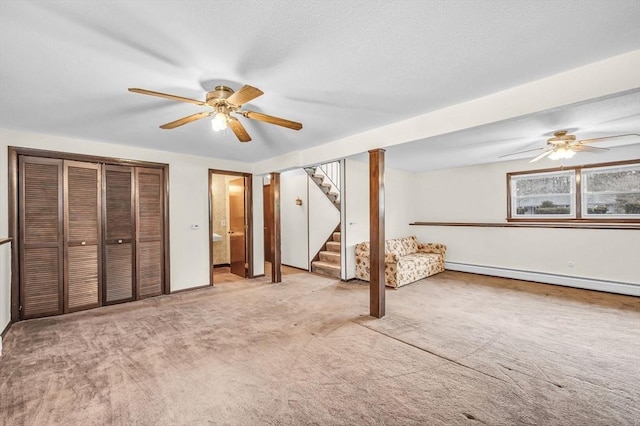 unfurnished bedroom featuring multiple closets, a ceiling fan, a textured ceiling, carpet flooring, and a baseboard radiator